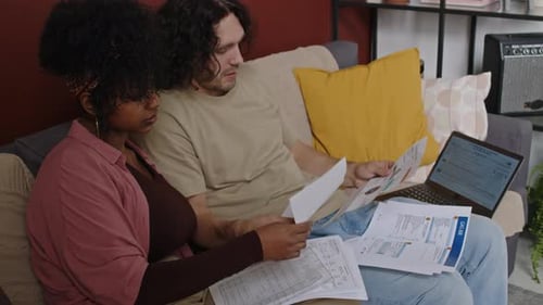 Couple Reviewing Bills Together on Couch at Home