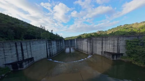 Hatillo Dam, concrete structure, Cotui in Dominican Republic. Drone flying under bulkheads, FPV