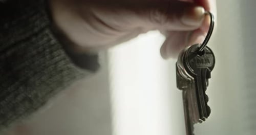 Close up of arm dangling bunch of house keys on keyring