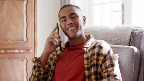 Smiling Young Adult Talking on Cellphone Indoors