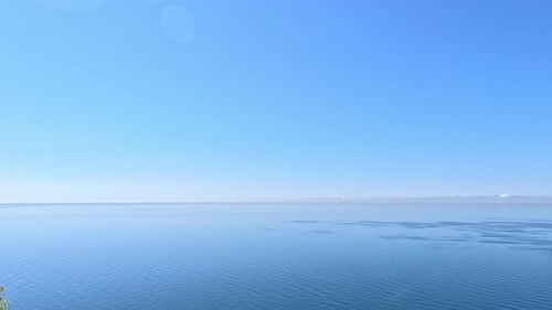 Aerial View on Calm Azure Sea and Volcanic Rocky Shores Small Waves on Water Surface in Motion Blur