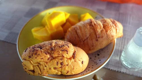 Close-Up of Fresh Pastries and Mango on a Breakfast Table
