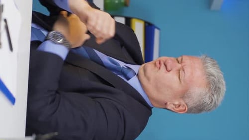 Man in Suit Rubbing Sore Shoulder in Office