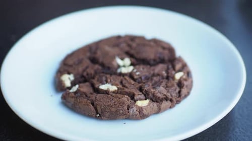 Chocolate Chip Cookie Being Broken on Plate