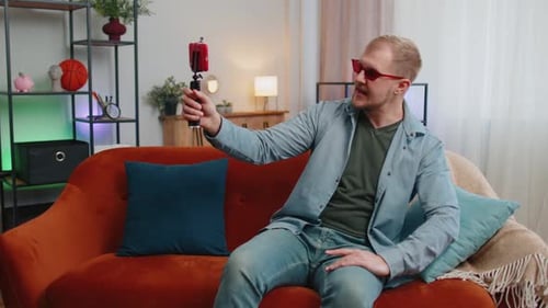 Man Talking to Phone on Tripod on Couch