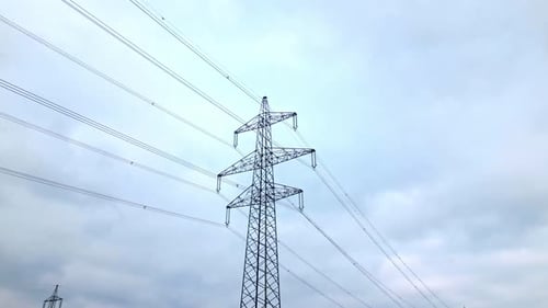 Transmission Tower And Overhead Power Line Against Clear Sky In Daytime. - aerial