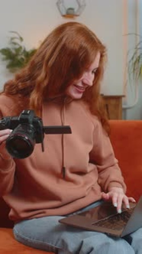 Woman Demonstrates Camera While Using Laptop At Home