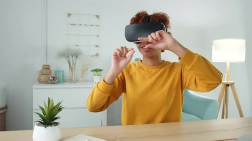Enthusiastic Young Adult Using VR Headset at Desk