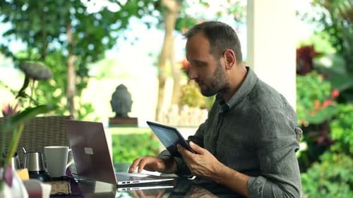 Happy Man Browsing on Tablet in Garden