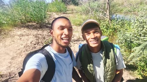 Two Friends Hiking in the Wilderness on Sunny Day