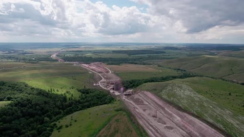 Ground Road Prepared for Asphalt Paving on Field with Trees