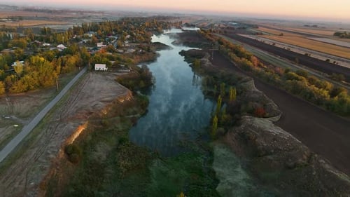 Aerial view of a misty river winding through a rural landscape