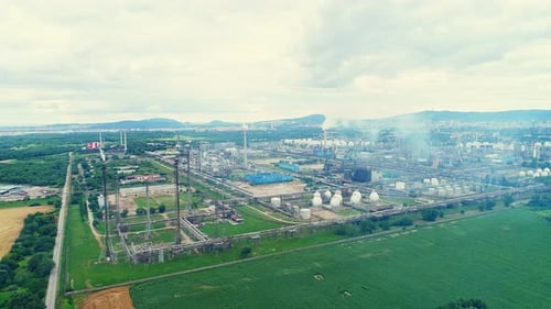 Pollution of the environment by a large technological factory. White smoke from chimneys. Huge urban