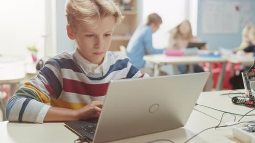 Smart Schoolboy Uses Laptop to Program Software for Robotics Engineering Class. Elementary School S