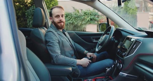 Man Sitting in Car Looking at Camera