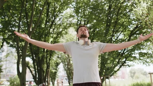 Man Stretching Arms in Park Relaxation Exercise