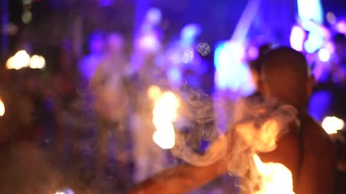Shirtless Performer Dancing with Flaming Torches at Night