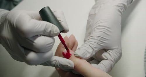 Applying Red Nail Polish at Nail Salon