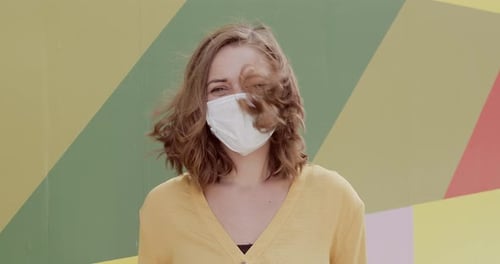 Woman Wearing Mask in Front of Colorful Wall