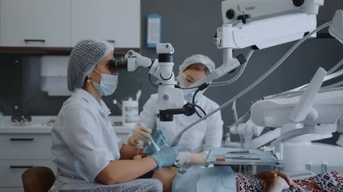 Modern Office Of Dental Clinic Female Dentist Looking At Operating Microscope During Operation