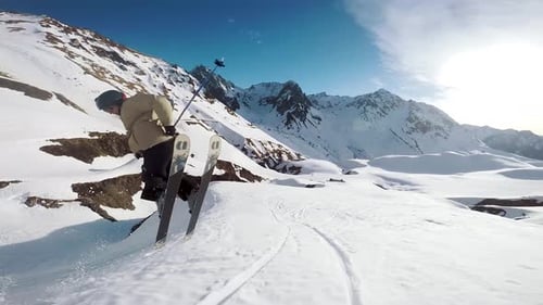 folgende Ansicht eines jungen Skifahrers beim Skifahren bei einem Sprungtrick in einem französischen Skigebiet
