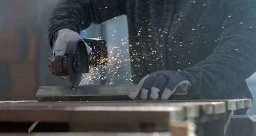 Close-up of angle grinder cutting metal with sparks flying in slow-motion at 800 fps,