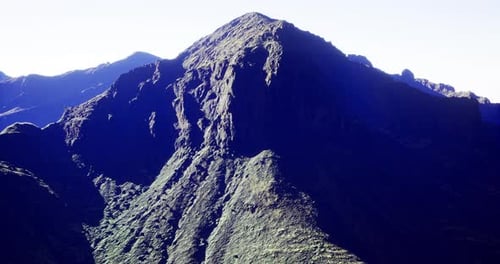 Majestic Mountain Peak Bathed in Morning Light Over Rugged Terrain