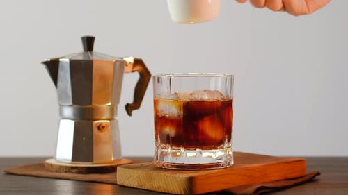 Pouring Milk into Iced Coffee Glass