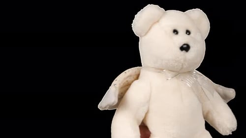 Stuffed and fluffy teddy bear toys with angel wings turns and looks around. Alpha channel included.