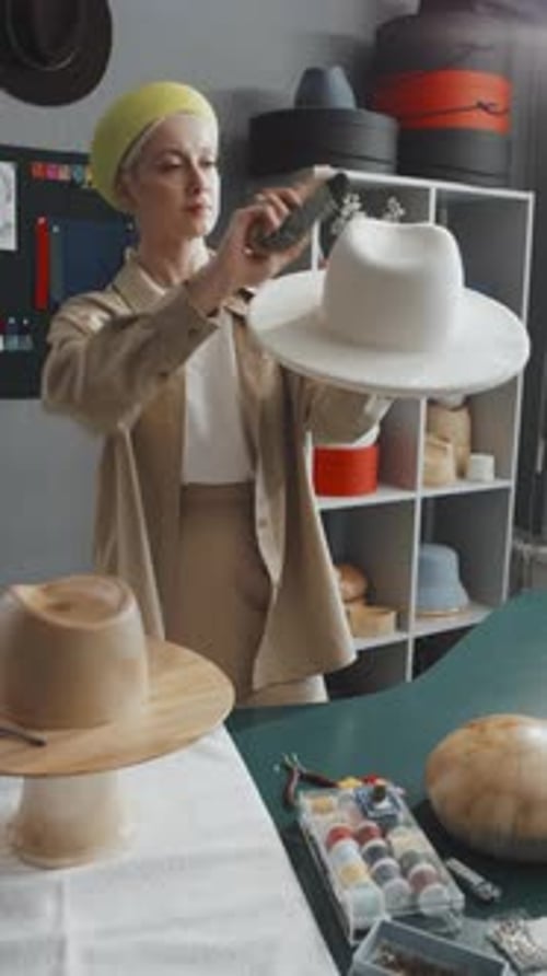 Woman Works on Fashionable Hat in Workshop