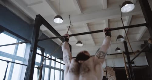 Athletic Young Muscular Caucasian Man Doing Extreme Pullup Exercises During Functional Workout in