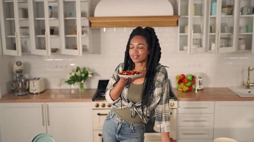 Smiling Woman Enjoys Salad in Bright Kitchen