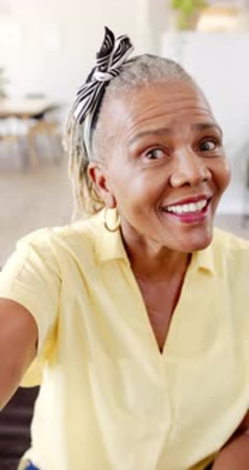 Vidéo verticale : Une femme afro-américaine âgée au sourire éclatant lève les yeux