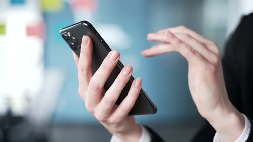 Hände einer Geschäftsfrau, die das Smartphone für die Kommunikation im modernen Büro verwenden. Frau beschäftigt sich mit dem Telefon