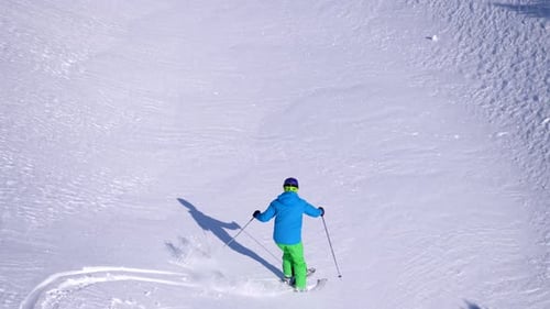 Person Skiing Down a Snow Covered Mountain