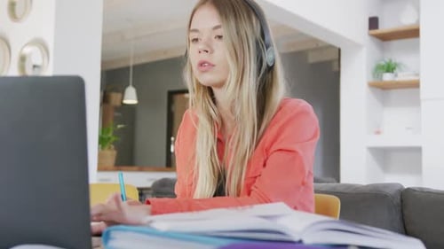 Woman Studies with Laptop and Headphones at Home