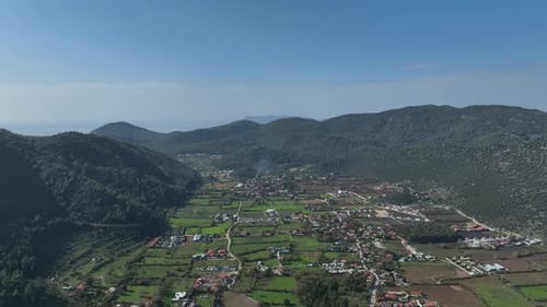 Aerial View of a Valley Village Surrounded by Mountains