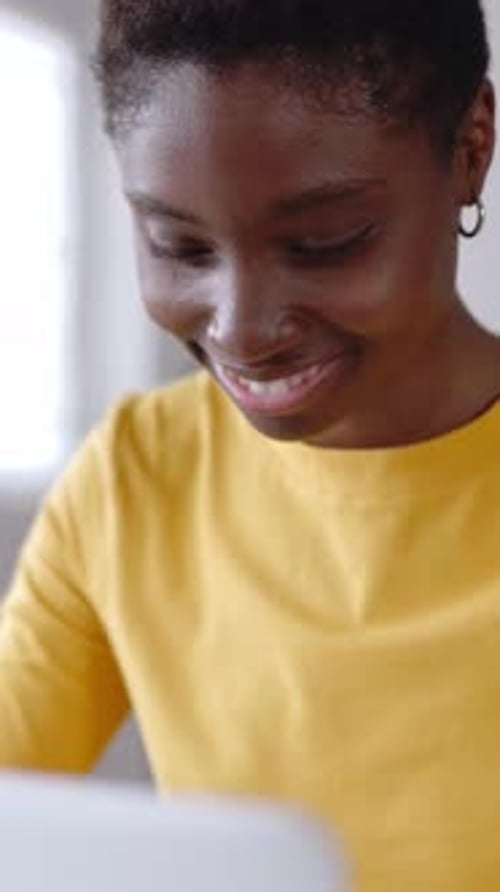 Smiling African Woman Student Using Laptop Computer for Online Learning at Home