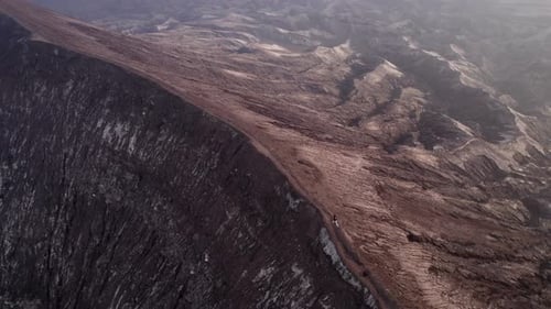 Aerial view of smoking volcano eruption at sunrise, famous Bromo, Indonesia.