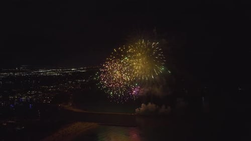 Vista aérea de fogos de artifício brilhantes explodindo com luzes coloridas sobre a costa do mar no Dia da Independência dos EUA