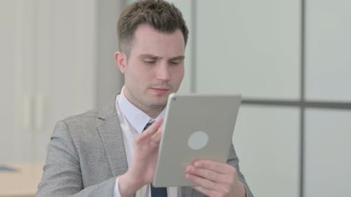Man Uses Tablet in Corporate Office Setting