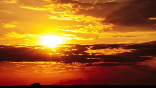 Dramatic Sunset with Sun Rays in the Sky Through Orange Layered Clouds Timelapse