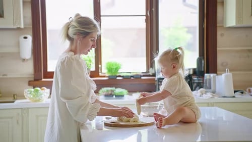 Madre e hija horneando masa en la cocina