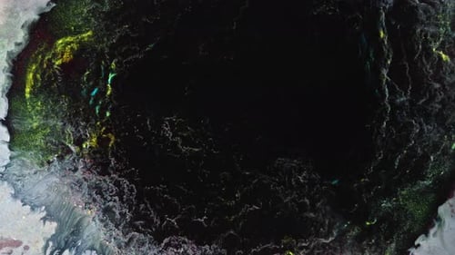 Colorful substances mixing in shot, forming vibrant and surreal abstract patterns