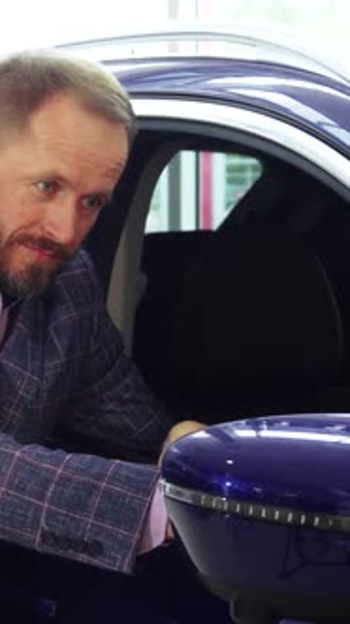 Man in Suit Touching Car Mirror