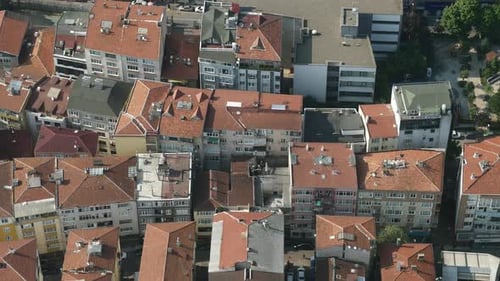 An Aerial View Capturing Urban Rooftops Adorned with Red Tiles and Varied Architecture