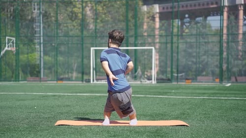 Active Man Stretching Outdoors on Yoga Mat