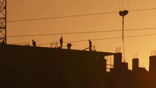 Construction of multi-storey apartment building, housing supply. Silhouettes builders working on con