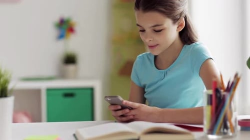 Young Girl Using Mobile Phone at Desk