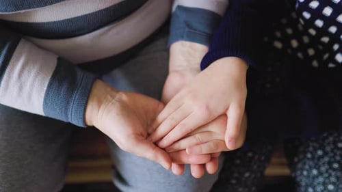 Child and Adult Holding Hands with Affection